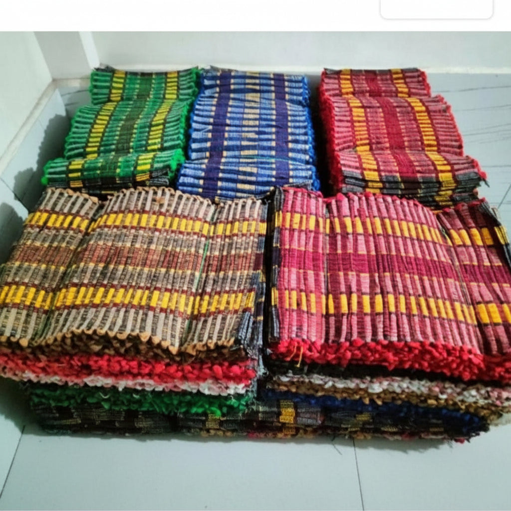 Stack of colorful woven mats on a white floor.