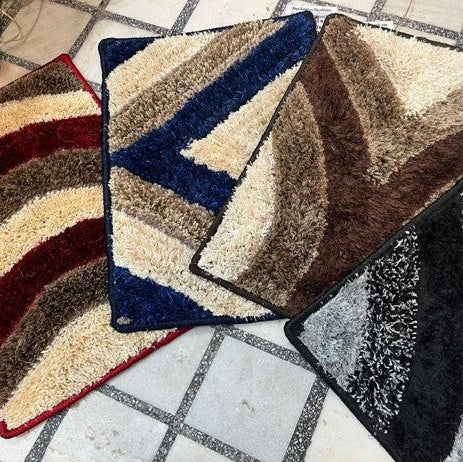 Three patterned bath mats on a tiled floor.