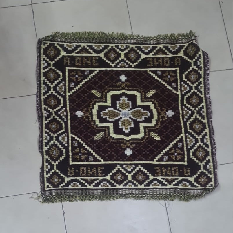Decorative rug with a geometric pattern on a tiled floor.