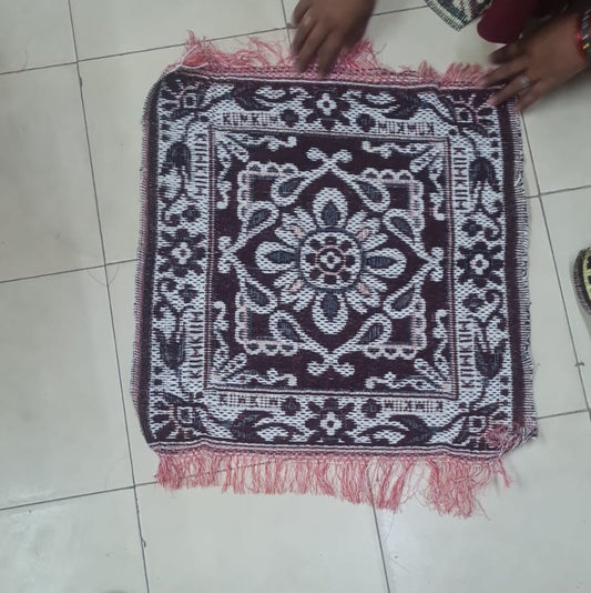 Person arranging a decorative mat on a tiled floor
