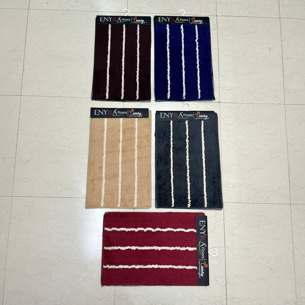 Four striped bath mats on a tiled floor with 'ENY' branding.
