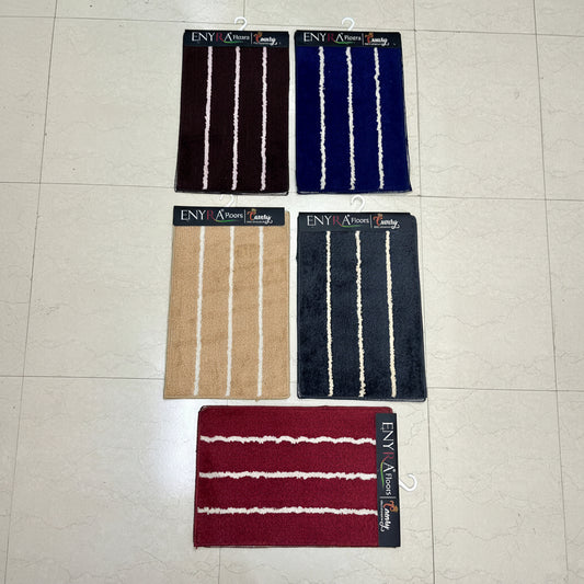 Four striped bath mats on a tiled floor with 'ENY' branding.