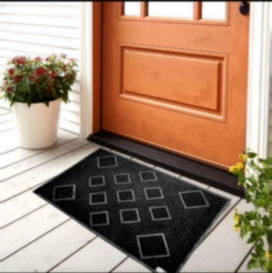Black doormat with geometric pattern on a wooden door