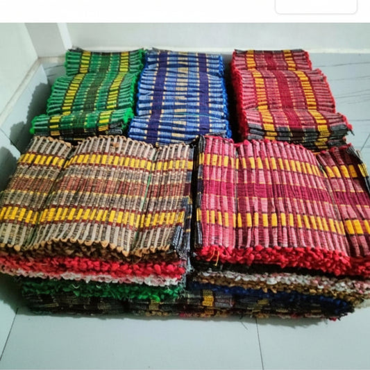 Stack of colorful woven mats on a white floor.
