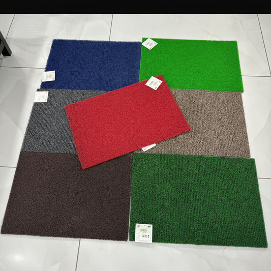 Color swatches of different colored mats on a tiled floor.