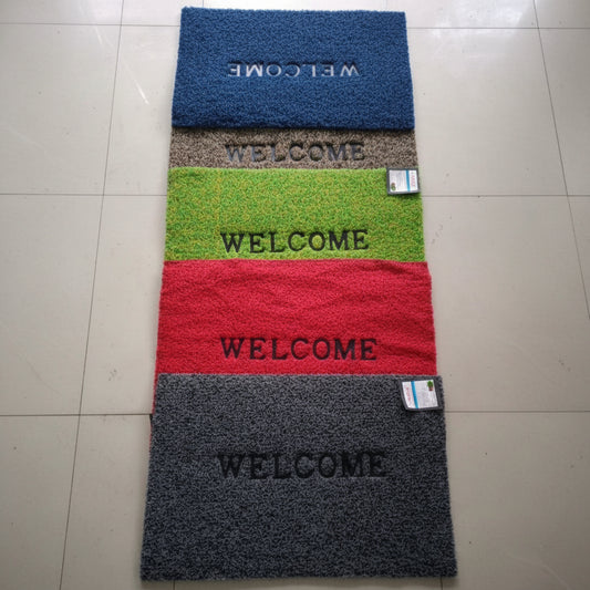 Set of four colorful doormats with 'WELCOME' text on a tiled floor.