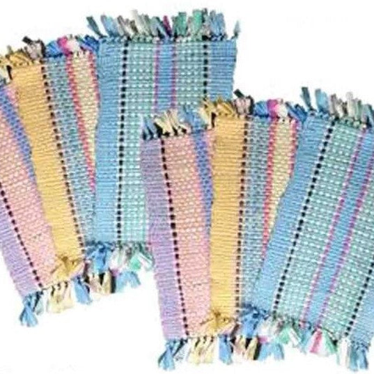 Set of colorful striped fabric placemats with tassels on a white background