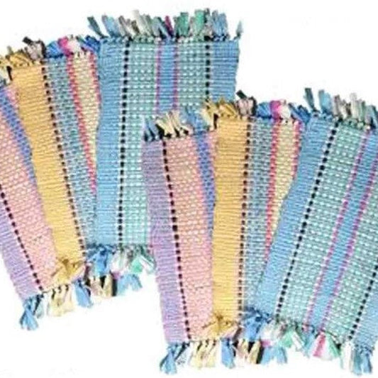 Set of colorful striped fabric placemats with tassels on a white background