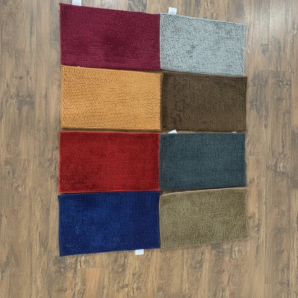 Nine square samples of different colored textured carpets on a wooden floor.