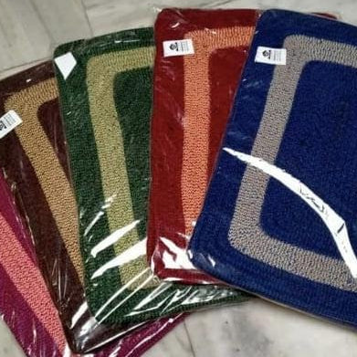 Set of colorful doormats with brand labels on a marble surface