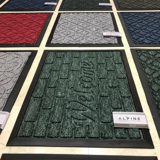 Collection of doormats with 'Welcome' text and Alpine branding.